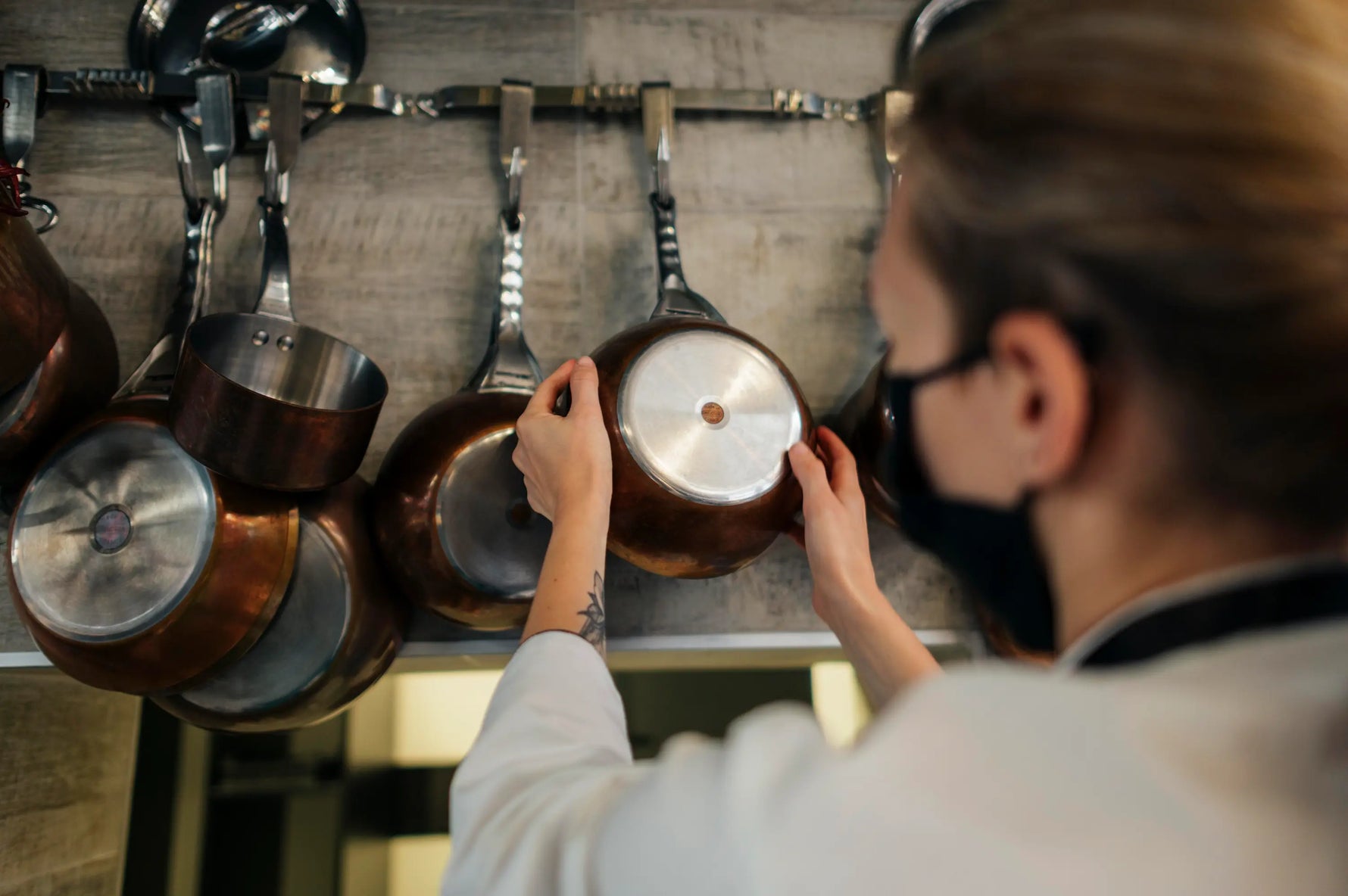 chef cuisinier dans un cuisine qui choisi une poêle en inox