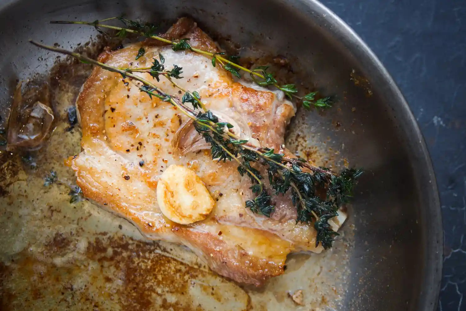 poisson qui colle au fond d'une poele en inox avec des aromates 