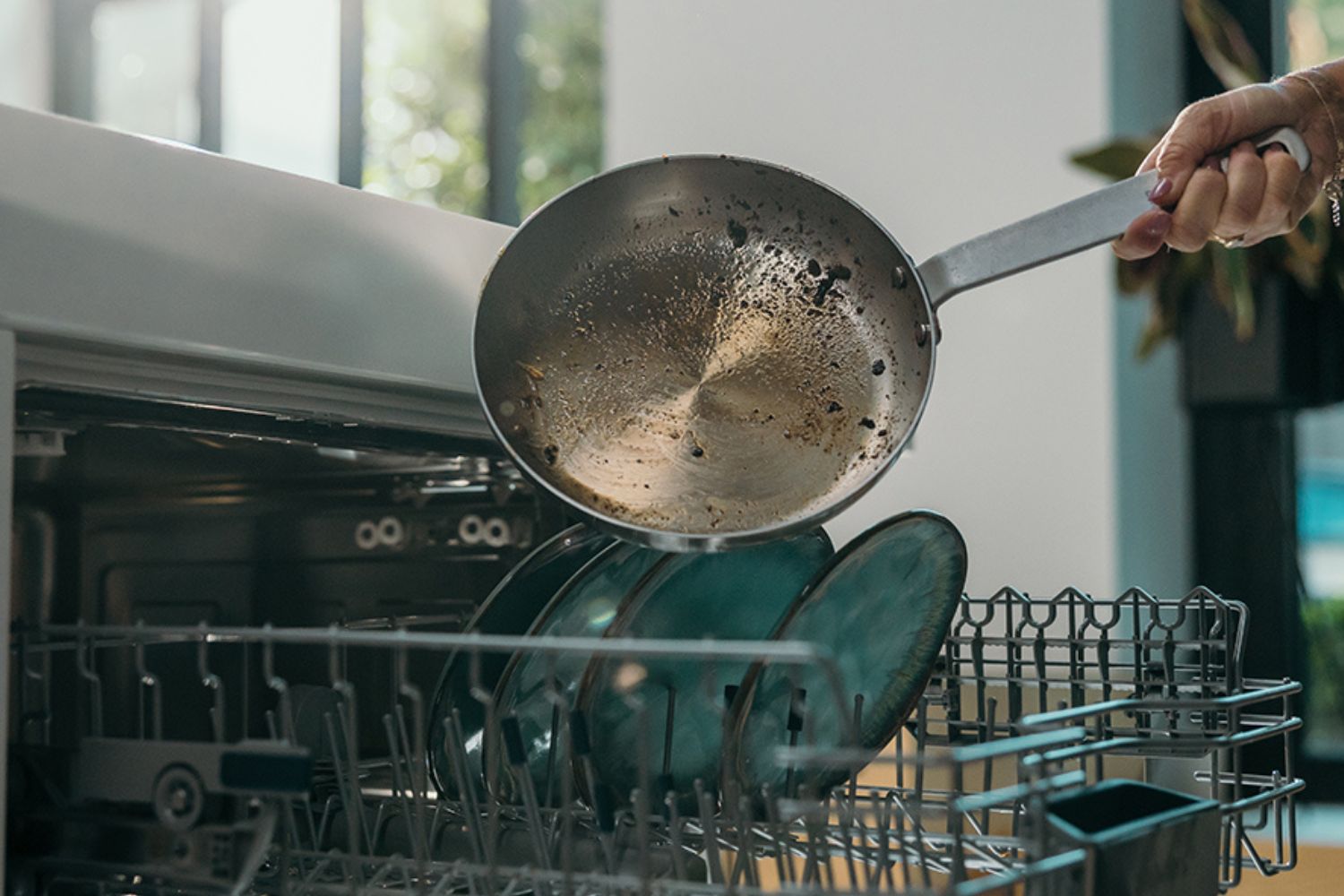 femme qui met une poêle en inox pour la nettoyer