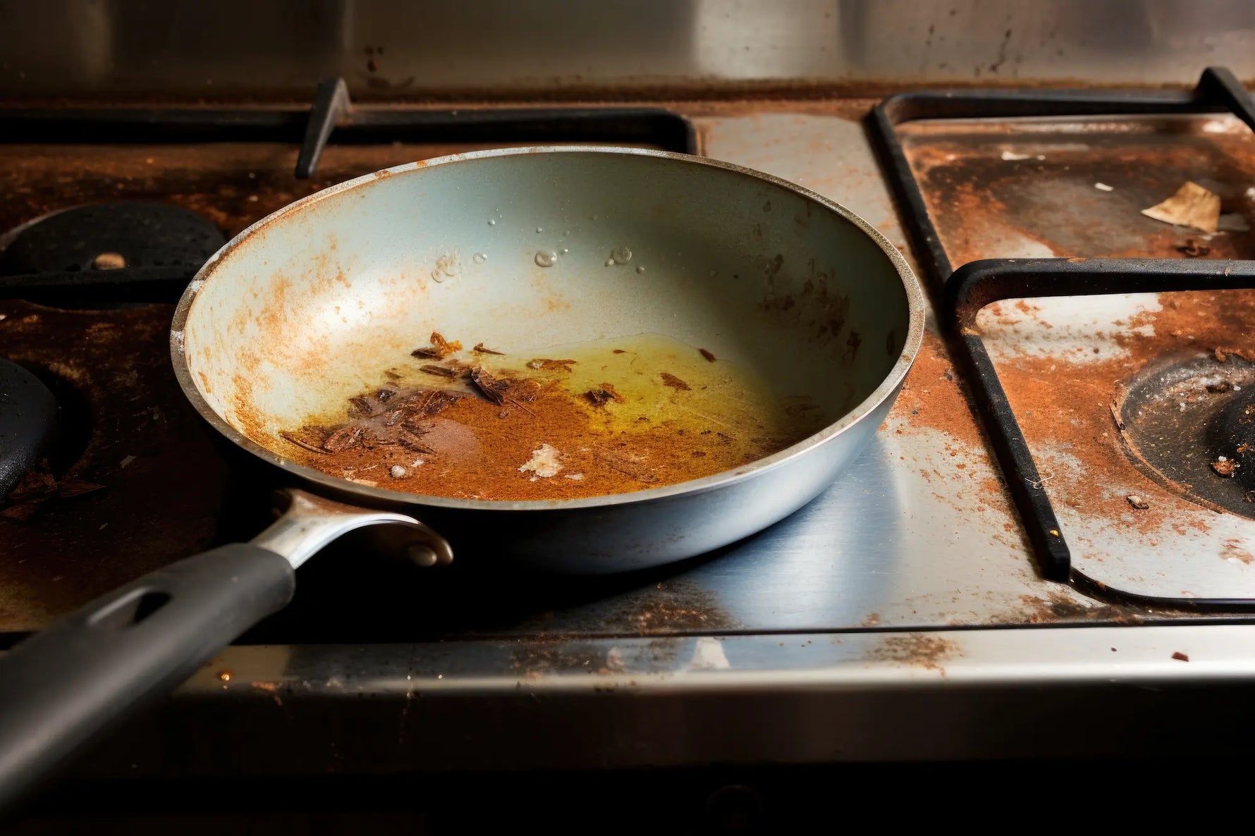 poele en ceramique bleu brulée sur une gaziniere sale