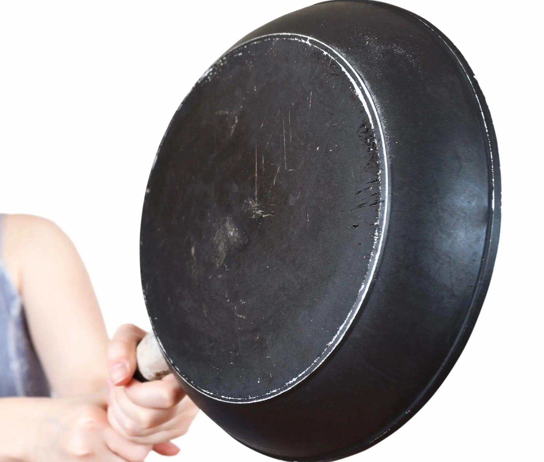 femme qui tient une poele en teflon qui est toute abimée 