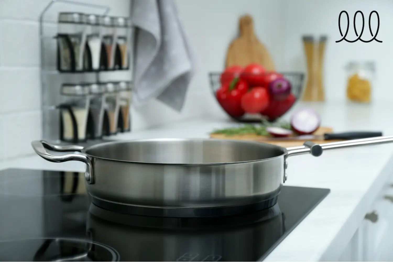 sauteuse en inox sur une plaque à induction avec des legumes et epices derrières