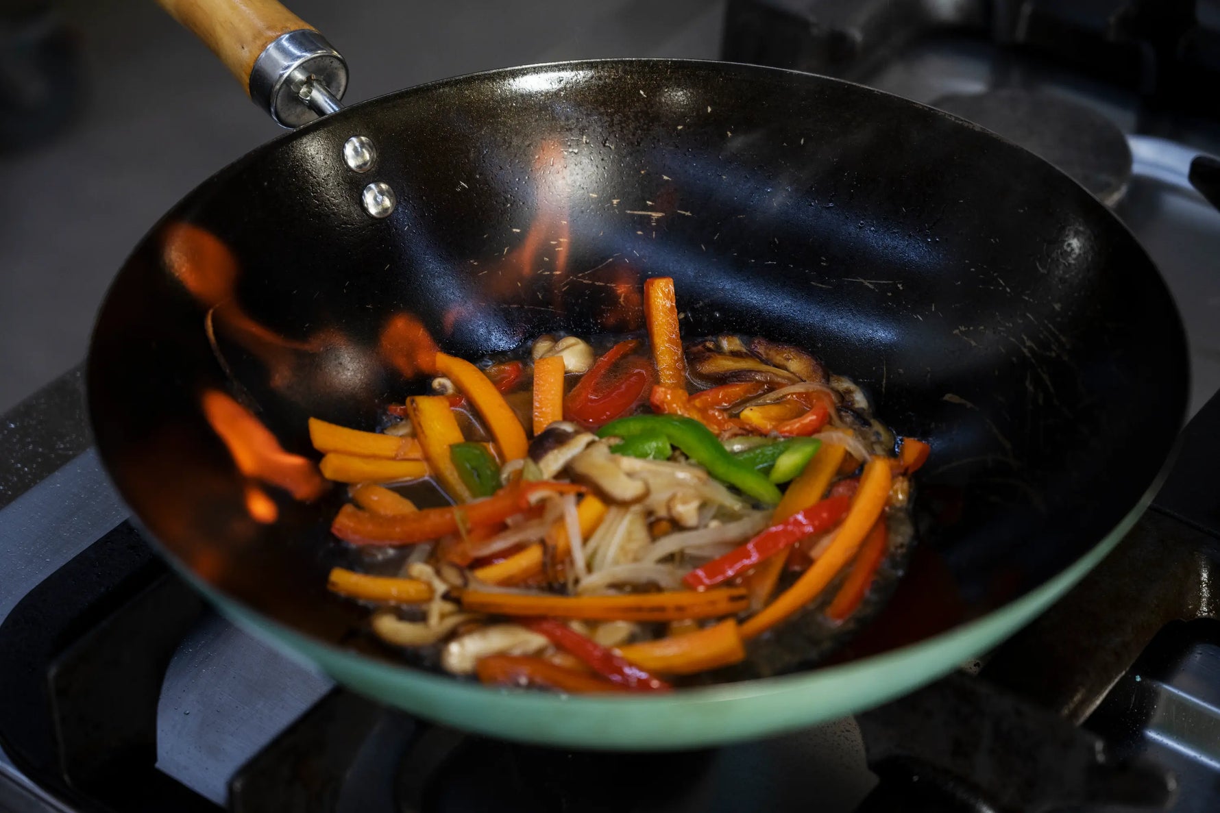 wok entrain de faire flamber des légumes colorés