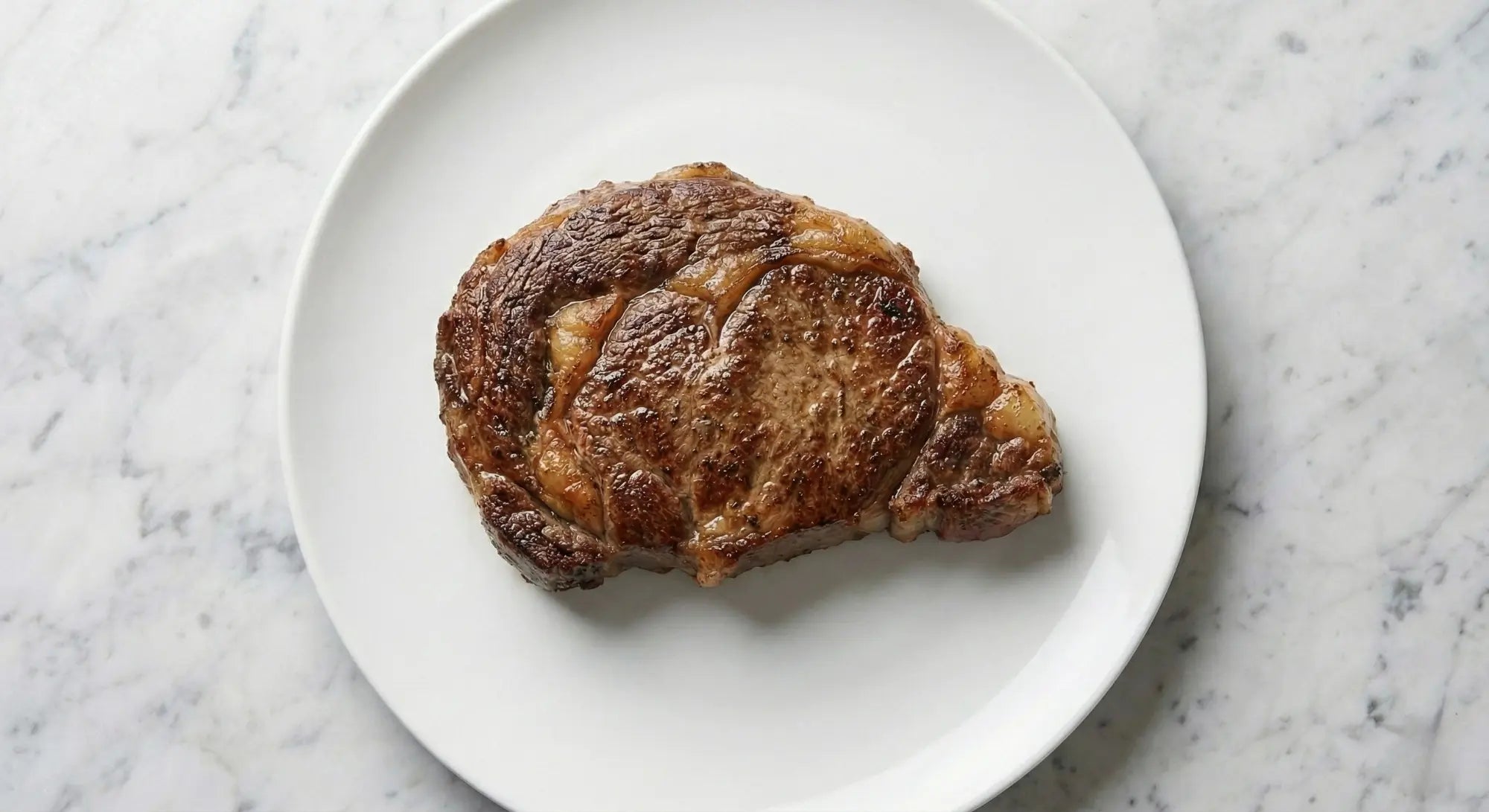 morceau de viande rouge dans une assiette cuite dans une poêle en inox 